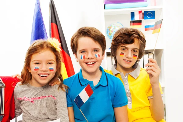 Pupilas com bandeiras nas bochechas na aula — Fotografia de Stock