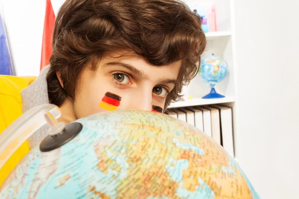 Schoolboy hiding behind the globe — Stock Photo, Image