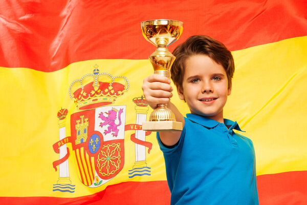 winner with cup against a flag of Spain