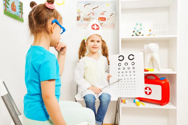 Girls playing a doctor ophthalmologist — Stock Photo, Image