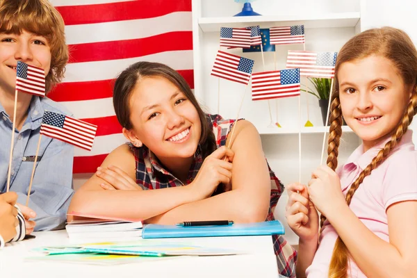 Estudiantes sonrientes con banderas americanas — Foto de Stock