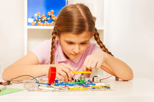 Girl looking at electronic constructor's wires — Stock Photo, Image