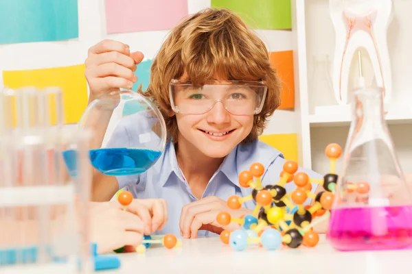 Niño con gafas de seguridad sosteniendo frasco — Foto de Stock