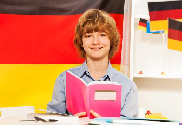 Sorrindo adolescente menino com livro didático — Fotografia de Stock