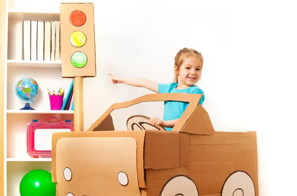 Chica sonriente y coche de cartón — Foto de Stock