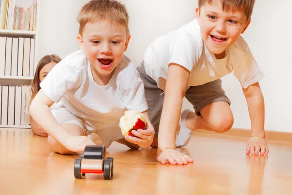 Niños jugando con coche de juguete de madera — Foto de Stock