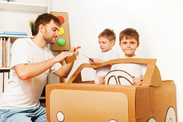 Vader en zonen speelgoedauto maken — Stockfoto