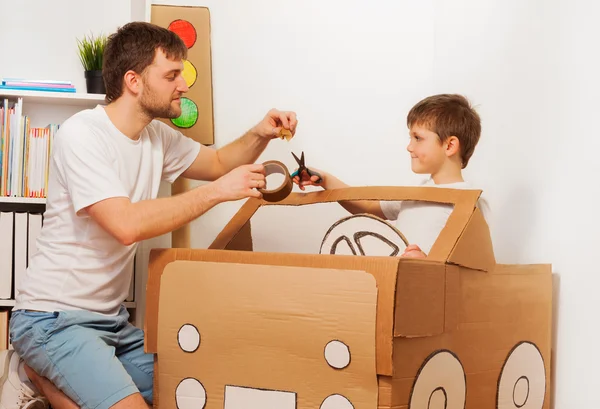 Dad and son and cardboard car — Stock Photo, Image