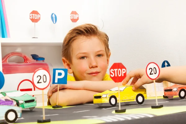 Мальчик играет в водителя с игрушечными машинами — стоковое фото