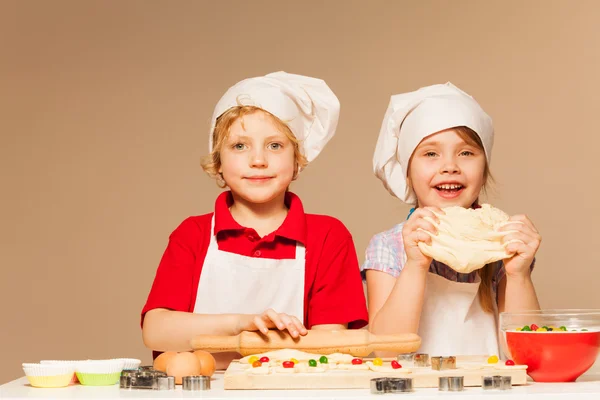 Girl and boy making together dough — Stock Photo, Image