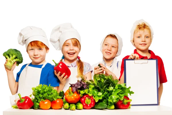 Мальчики и девочка со свежими овощами — стоковое фото