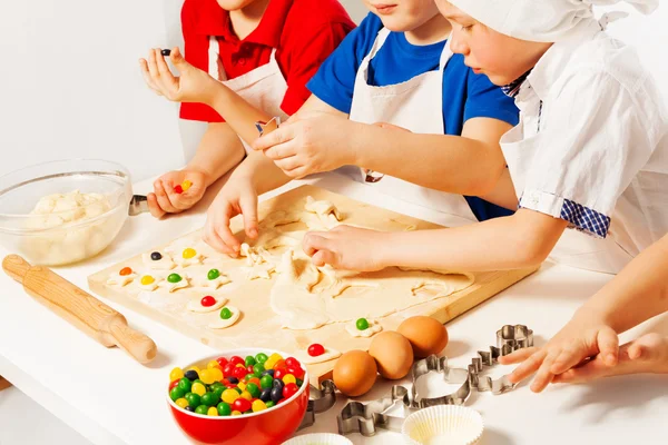 Kinder in weißen Schürzen machen Bonbons — Stockfoto