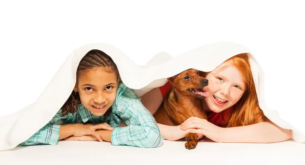 Girls  under blanket with dog — Stock Photo, Image