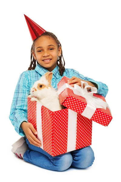 Mädchen öffnet Geschenk mit echtem Hasen — Stockfoto