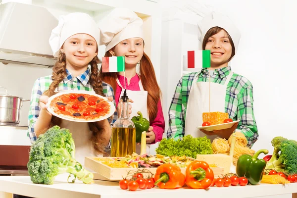 Мальчик и девочки с традиционной итальянской кухней — стоковое фото
