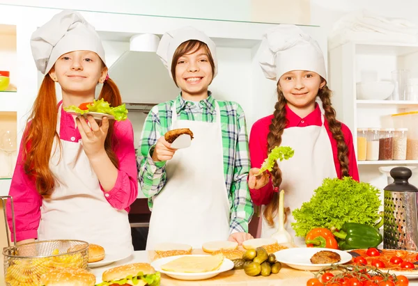 Boy and girls in uniform holding ingredients — Stock Photo, Image