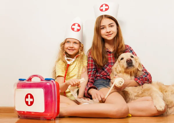 Meninas que colocam veterinários com seu animal de estimação — Fotografia de Stock