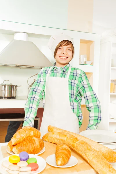 Giovane panettiere con panetteria fresca — Foto Stock