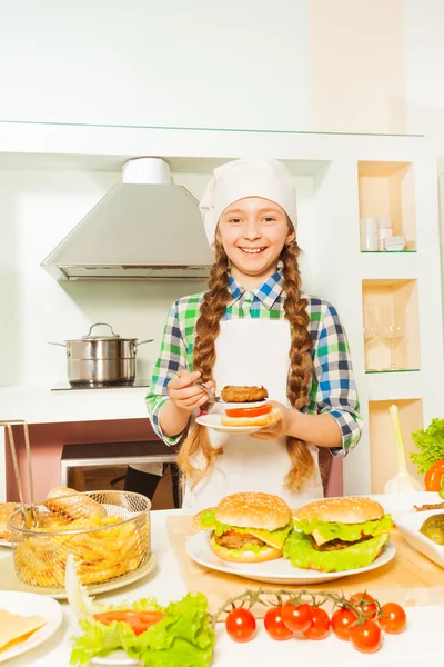 Gülümseyen kız hamburger hazırlama — Stok fotoğraf