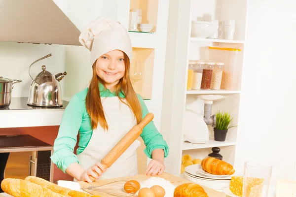 Sorrindo menina fazendo massa de padaria — Fotografia de Stock