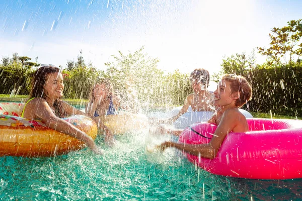 Şişme Yüzüklü Dört Mutlu Çocuk Yüzme Havuzunda Birlikte Oynuyorlar — Stok fotoğraf