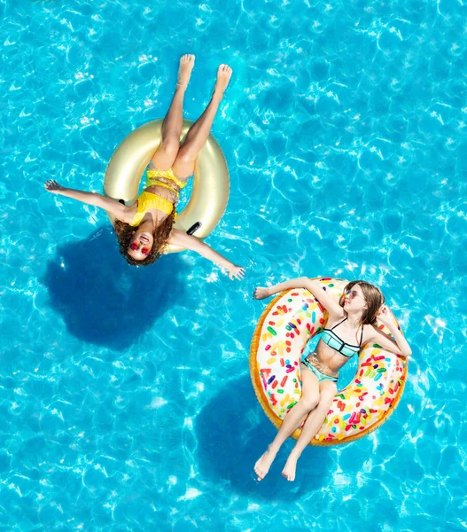 Zwei Glückliche Mädchen Mit Sonnenbrille Schwimmen Auf Aufblasbaren Donuts Pool — Stockfoto