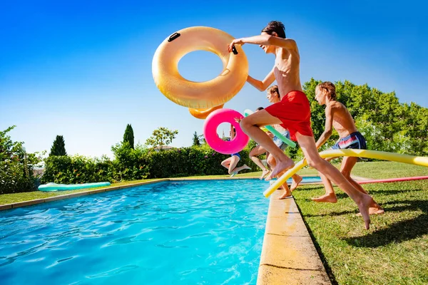 Grupp Glada Tonåringar Med Uppblåsbara Bojar Hoppa Och Plaska Vatten — Stockfoto