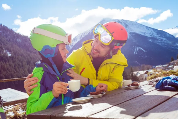 父亲抱着穿着滑雪服的小男孩 一边滑雪一边欣赏高山美景 一边享受午休 — 图库照片