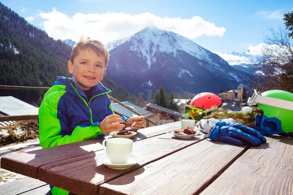 在户外咖啡店滑雪后 孩子们在外面吃着快乐的午餐 桌上放着茶和蛋糕 俯瞰高山美景 — 图库照片