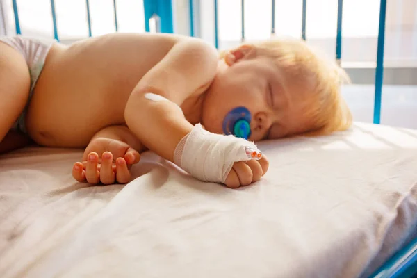 彼の手とペースメーカーでカテーテルと病院で小さな幼児の睡眠の近い写真 — ストック写真
