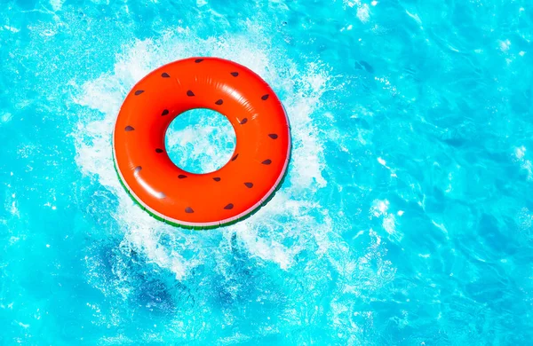 用种子浮标飞溅的扁平红色西瓜从上面掉到游泳池里去了 — 图库照片
