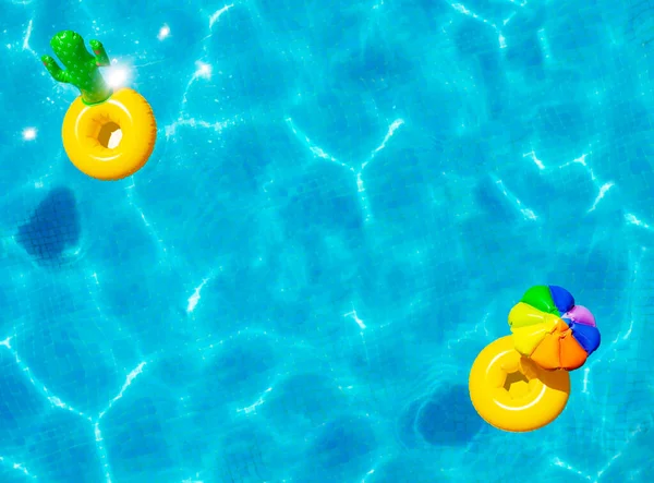 可伸缩的黄色遮阳伞和仙人掌浮标在游泳池的视野中游泳 — 图库照片