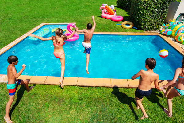 Многие маленькие дети прыгают в бассейн, чтобы нырнуть сверху