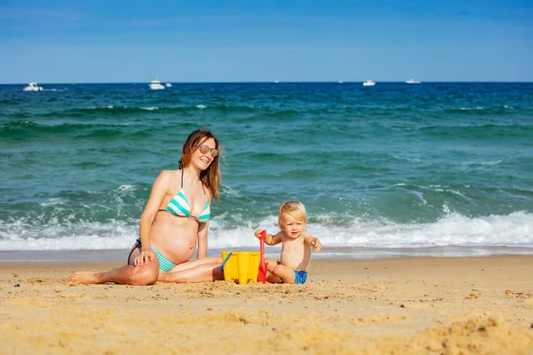 Peuter Jongen Zitten Zwanger Jong Moeder Het Zand Strand Spelen — Stockfoto