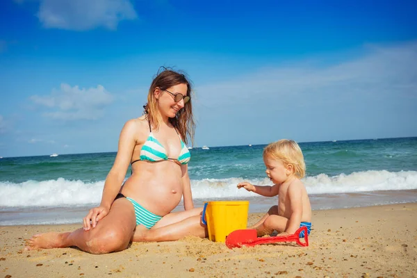 Liten Småbarn Pojke Sitta Med Gravid Ung Mor Sandstranden Leker — Stockfoto