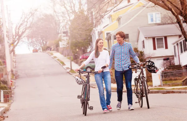 Feliz Jovem Casal Andar Segurando Bicicletas Falando Sobre Vista Urbana — Fotografia de Stock