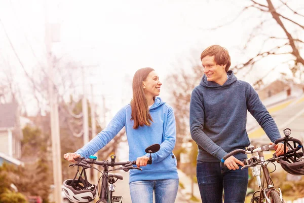 Feliz Jovem Casal Andar Segurando Bicicletas Falando Sobre Vista Urbana — Fotografia de Stock