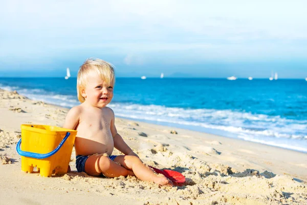 Mały Szczęśliwy Blondyn Siedzieć Małym Wiadro Plaży Pobliżu Morza — Zdjęcie stockowe