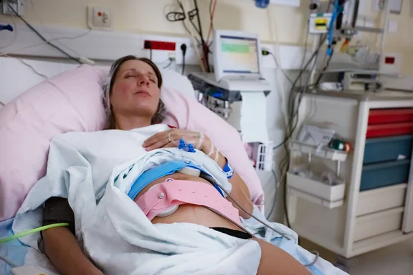 妊娠中のモニターを持つ女性は出産前に労働中に病院に横たわっていた — ストック写真