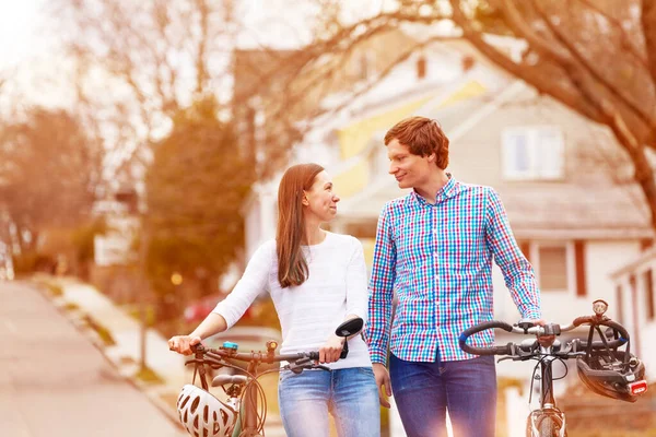 美丽的年轻夫妇骑着自行车在典型的美国城市街道上散步 — 图库照片