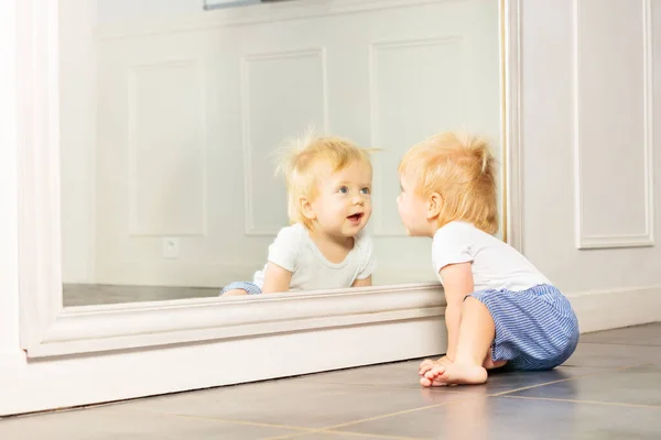 小さなブロンドの幼児の男の子の肖像画でザ鏡座って上の床 — ストック写真