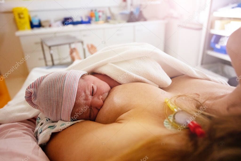 Mother breast feeding newborn baby after labor in hospital