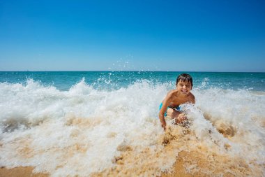 Sahildeki dalgalarda oynayan küçük bir çocuğun aksiyon filmi.