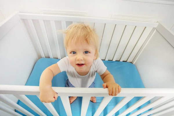 可爱的金发碧眼的小男孩在婴儿床里抬头看的画像 — 图库照片