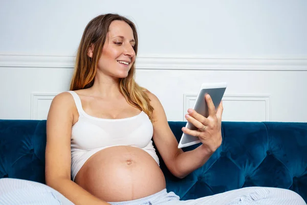 Zavřít Obrázek Šťastně Usmívající Těhotné Ženy Sedět Pohovce Ebook Reader — Stock fotografie