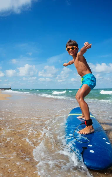 Foto Ragazzo Che Cavalca Tavola Surf Sulla Spiaggia Durante Lezione — Foto Stock