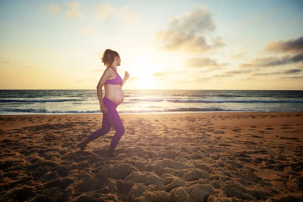 Gravid Kvinna Jogging Sand Ocean Strand Med Solnedgång Över Vatten — Stockfoto