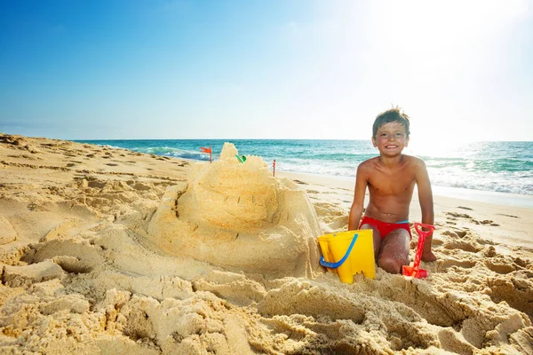 Щасливий Красивий Хлопчик Будує Піщаний Замок Морському Пляжі Відпустці Сидить — стокове фото