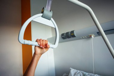 Hand hold hospital handle hanging over bed and room window