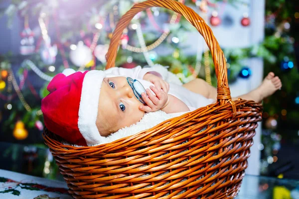 小女婴在篮子里靠近新年树的地方拿着奶嘴 — 图库照片